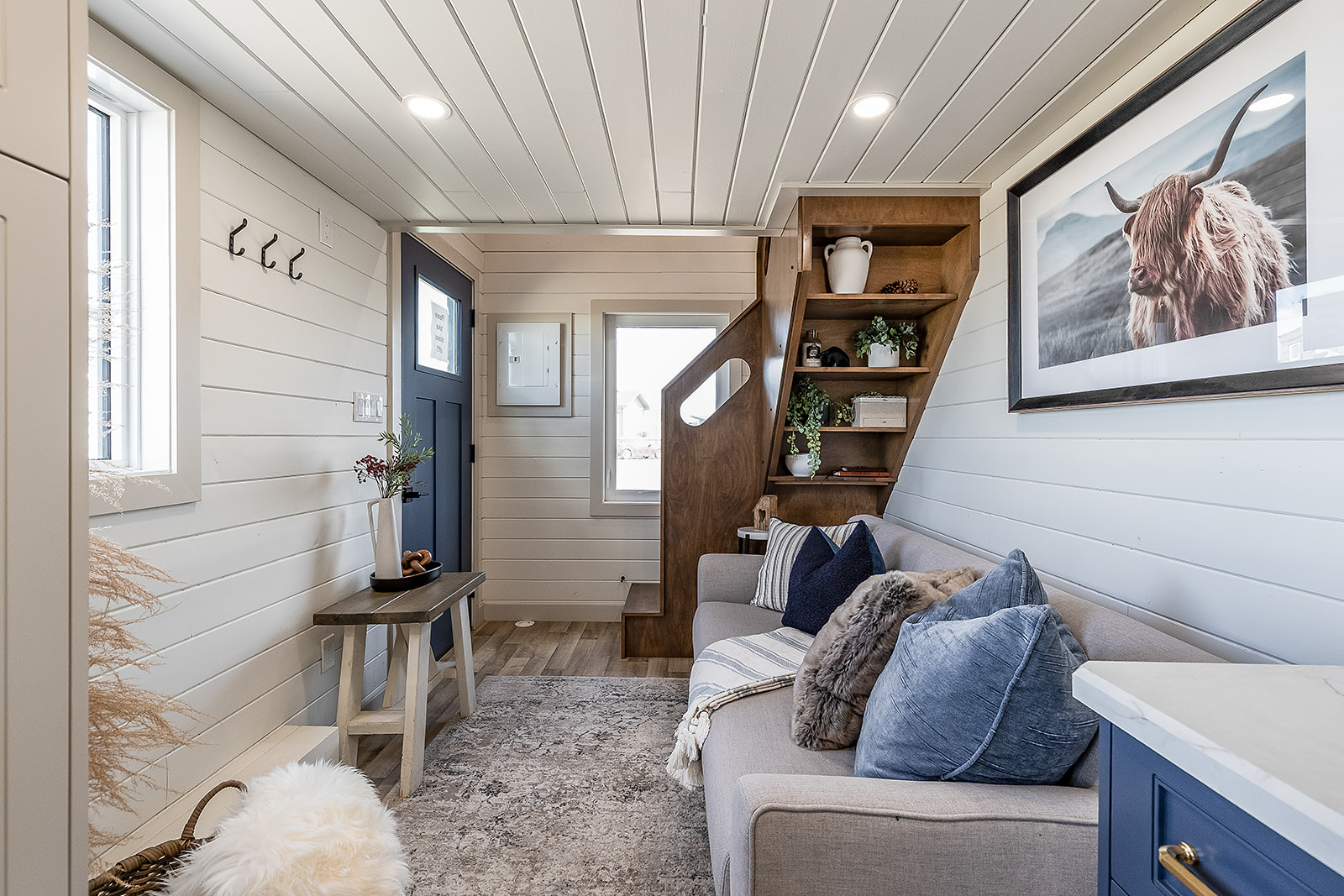 A tiny home living space and entryway with smart storage