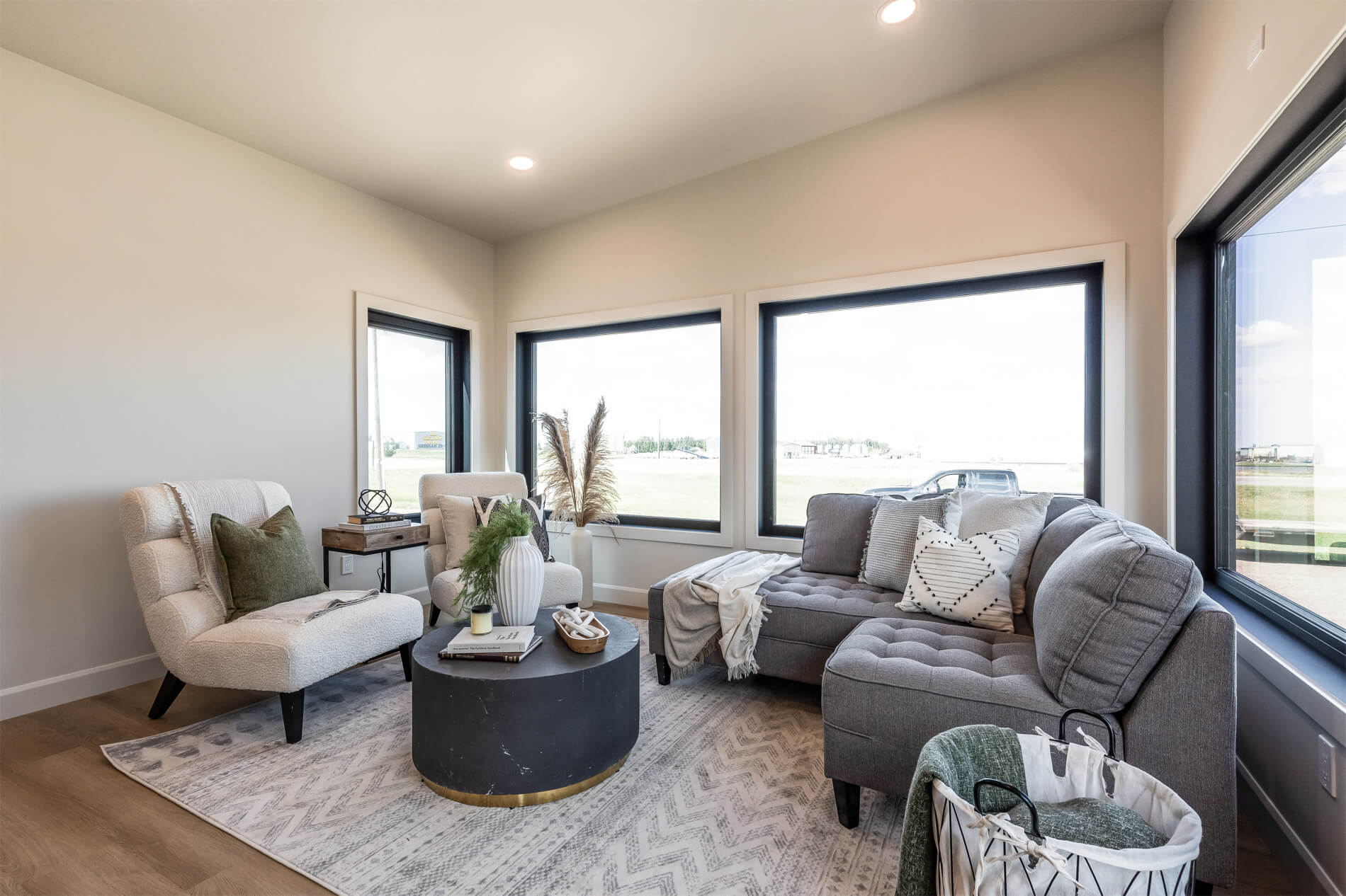 A spacious living room in a tiny home with large windows and high ceilings