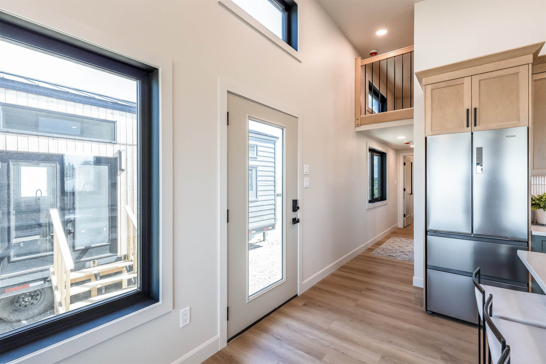 Tiny home entryway with tons of natural light and a loft above