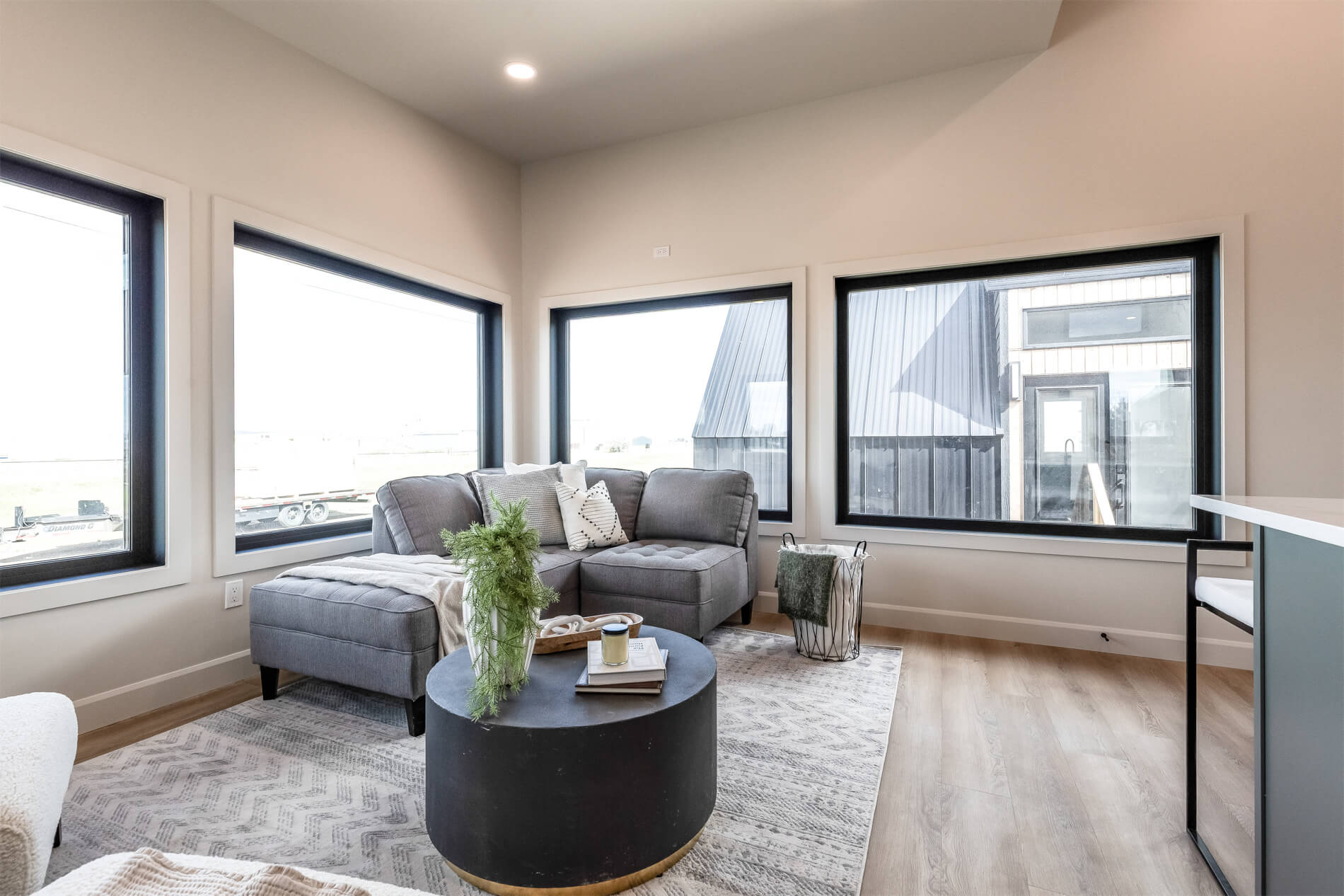 A spacious living room in a tiny home with large windows and high ceilings