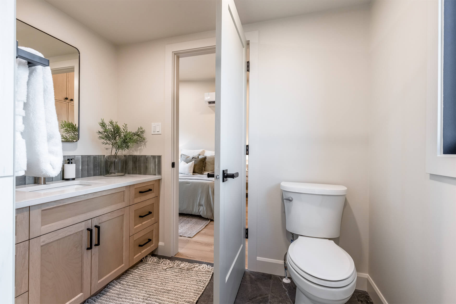 A tiny home bathroom with white walls and a light wood vanity