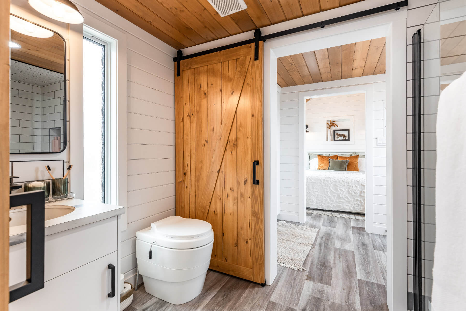 Tiny home bathroom with a rustic sliding barn door