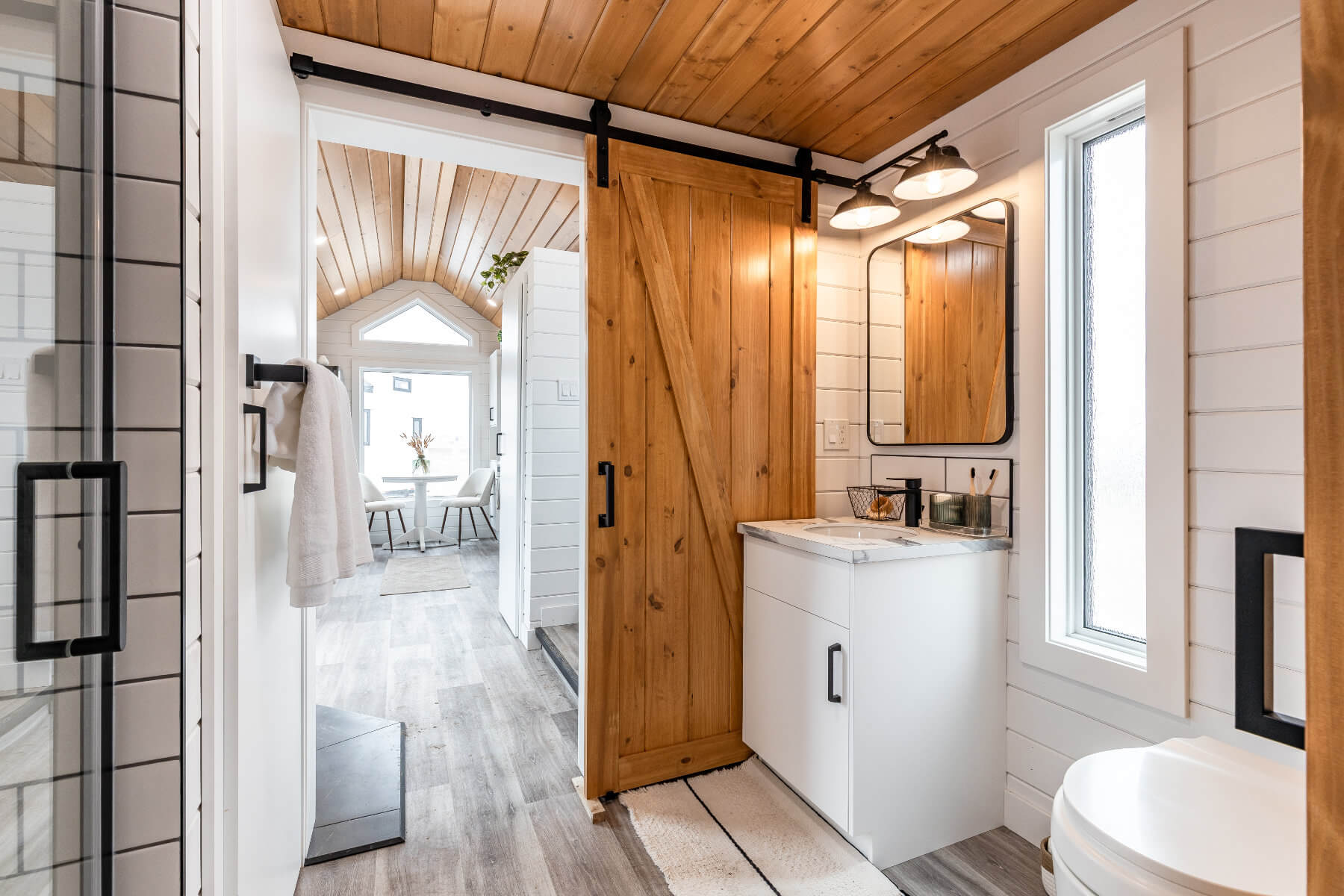 Tiny home bathroom with a rustic sliding barn door