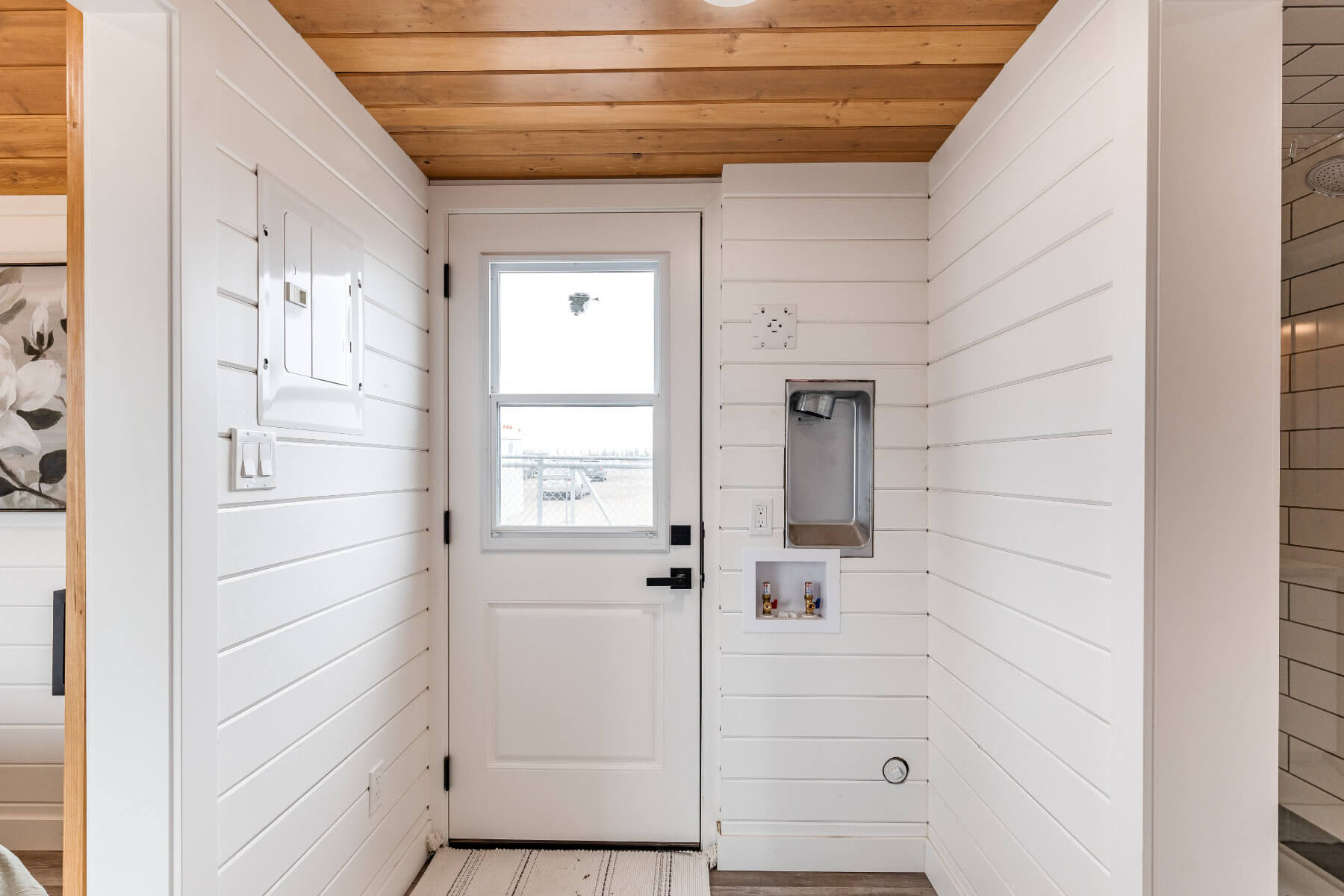 Tiny home entryway with white walls and a white door