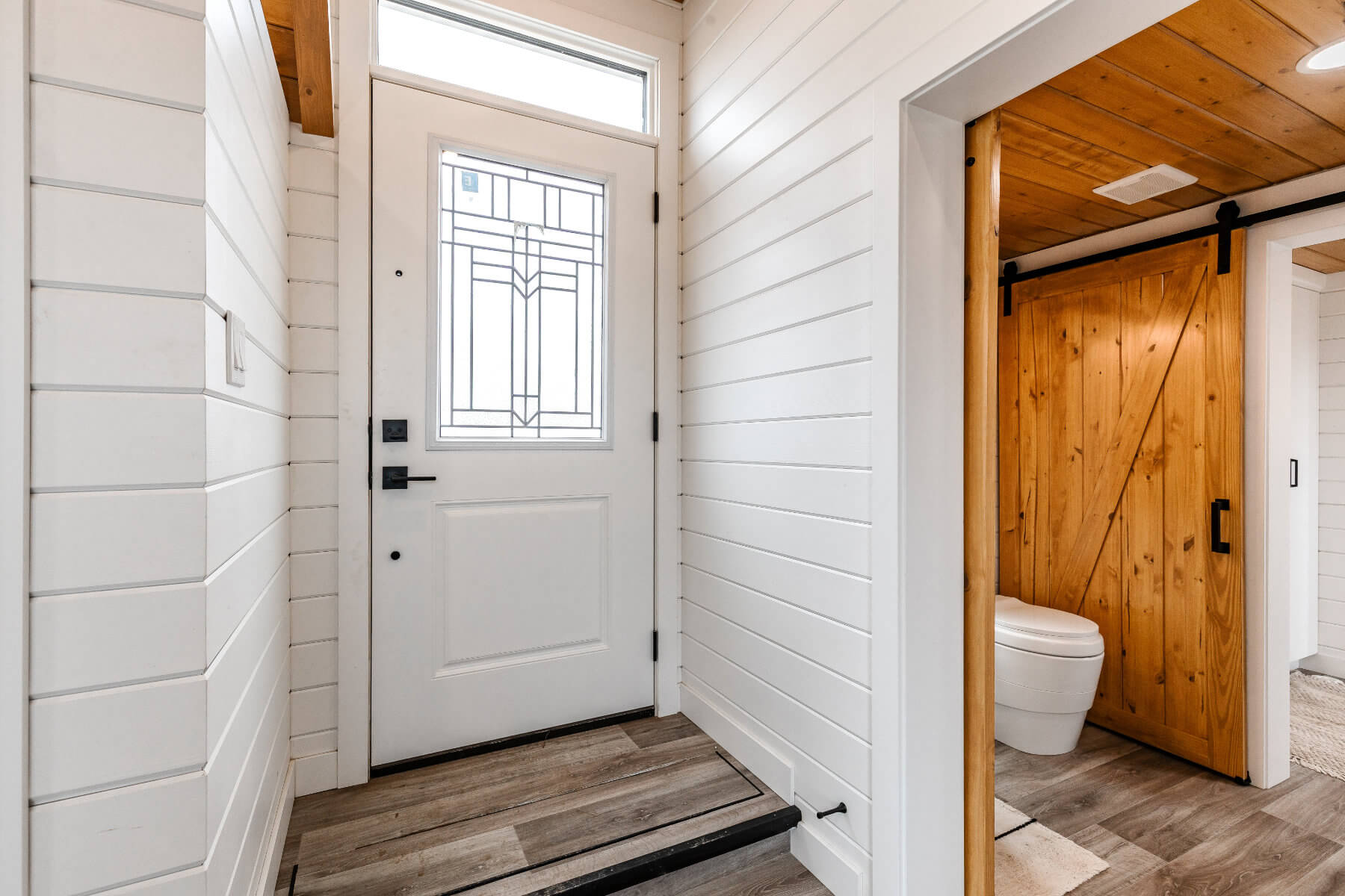 Tiny home entryway with white walls and a white door