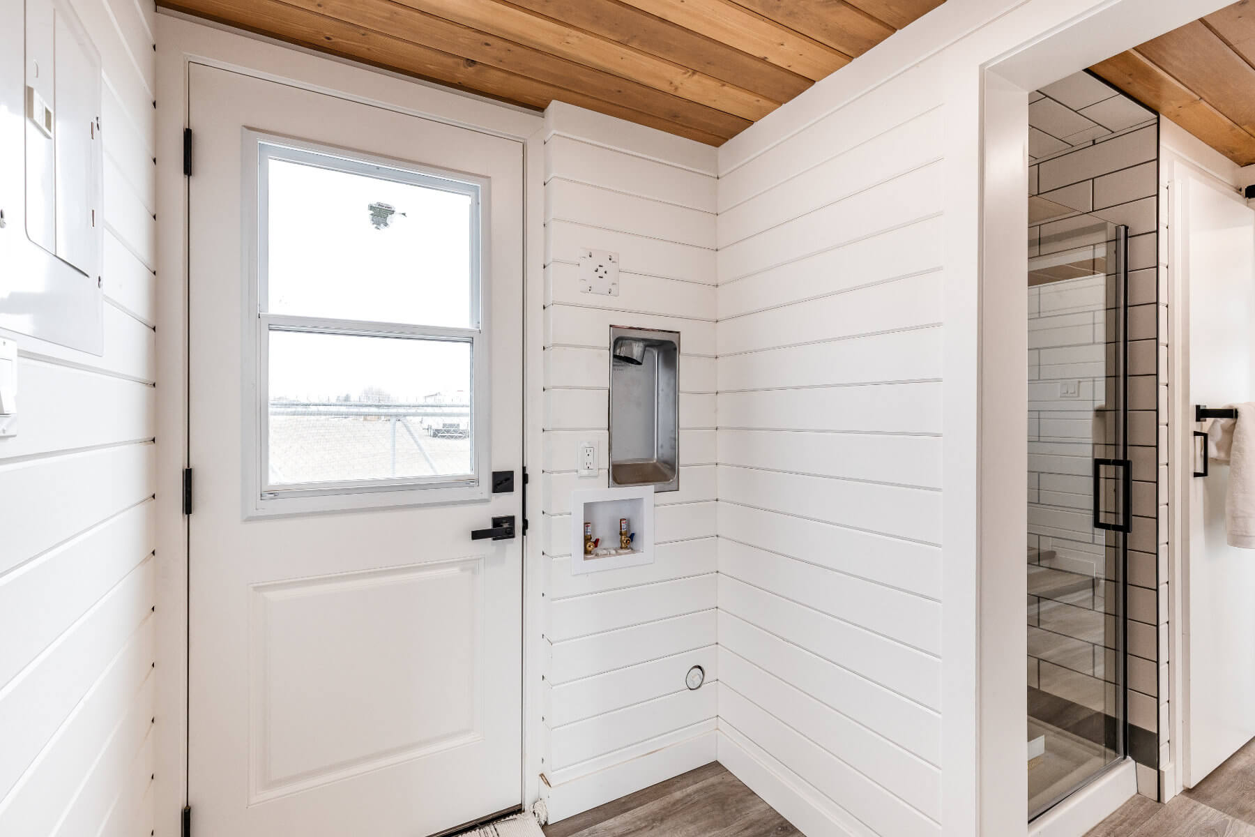 Tiny home entryway with white walls and a white door