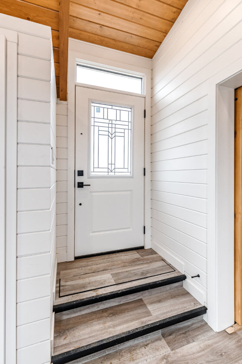 Tiny home entryway with white walls and a white door